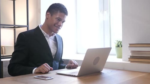 Professional Man on Video Call in Bright Office