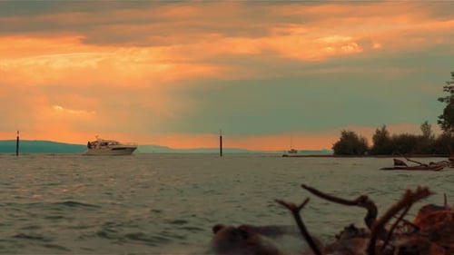 Yate que entra al puerto con un cielo dorado al atardecer y bonitas olas. 4K a 25 fps.