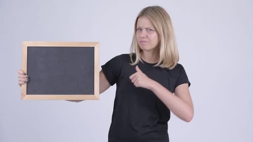 Woman Points to Chalkboard, Gives Thumbs Down