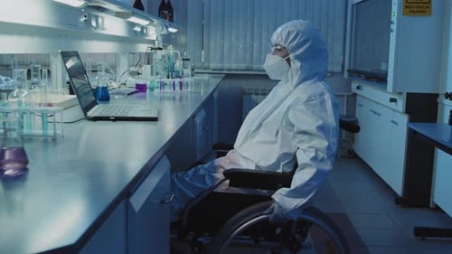 Scientist in Wheelchair Works at Computer in Lab