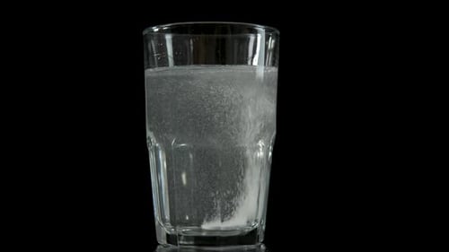 Effervescent Tablet Dissolving in Clear Glass of Water