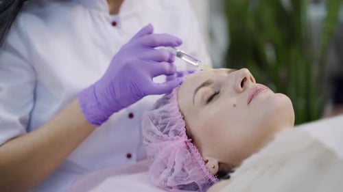 Woman Receives Injection on Forehead for Beauty Treatment