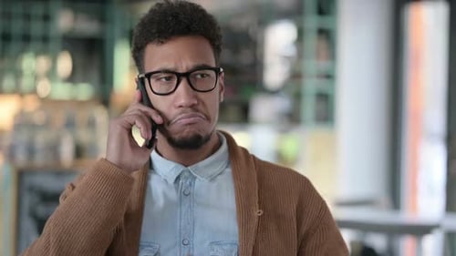 Annoyed Man Arguing on Mobile Phone Indoors