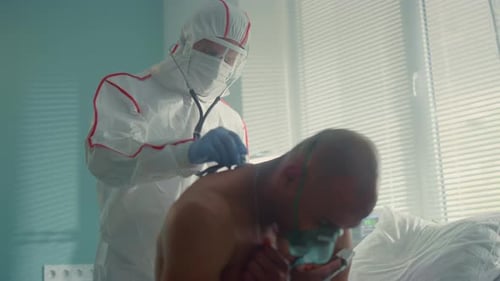 Doctor Listens to Patient's Lungs in Hospital Room