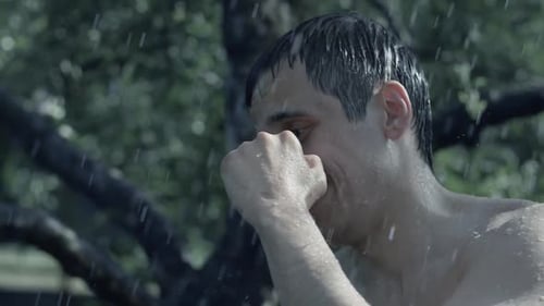 Shirtless Man Shadow Boxing Outdoors in the Rain