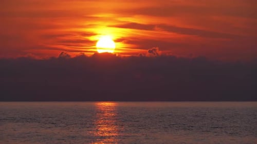 Sonnenuntergang in den Wolken über dem Meer. Orange Path Sonnenuntergang im Meer