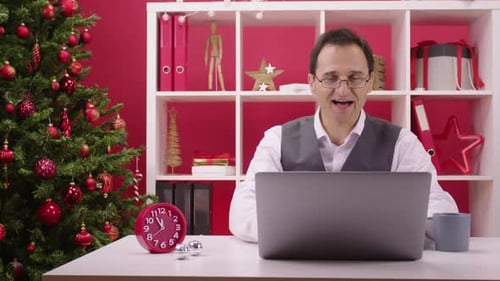 Man Celebrates Christmas Achievement in Decorated Office