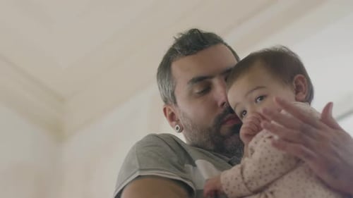 Loving Father Holds Baby Affectionately Inside Home