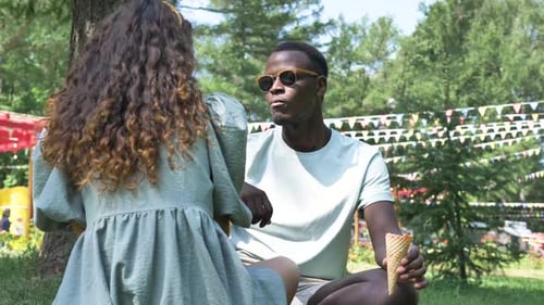 Couple Talking and Eating Ice Cream in Park