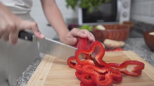 Slicing Red Bell Pepper for Cooking in Kitchen
