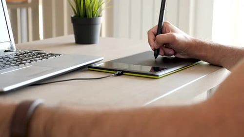 Man Working on Graphics Tablet and Laptop