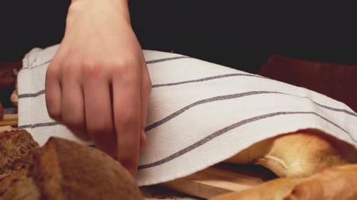 Baker Putting Freshly Made Bread on Table