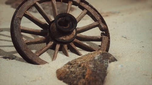 Weathered Wooden Wagon Wheel on Sandy Terrain