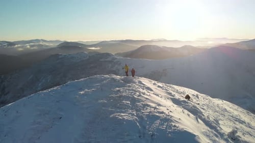Drone Spin Orbit Around Couple of Hikers Ascending a Summit