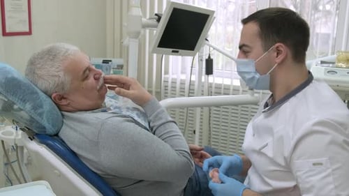 Dentist Discussing Dentures with Patient in Dental Clinic