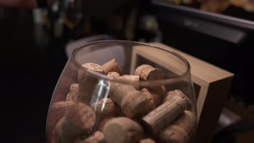 Corchos de vino que caen de botellas de vino en un frasco de vidrio