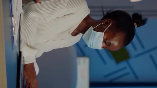 Employé africain avec masque de protection travaillant sur un ordinateur portable