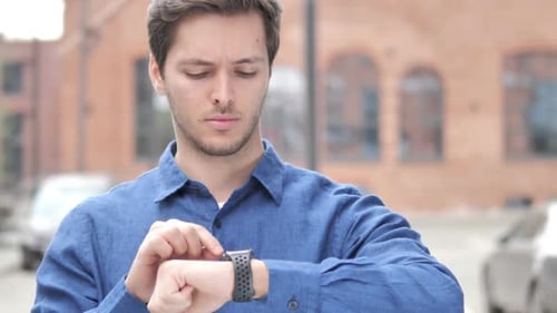 Man Using Smart Watch in Urban Setting