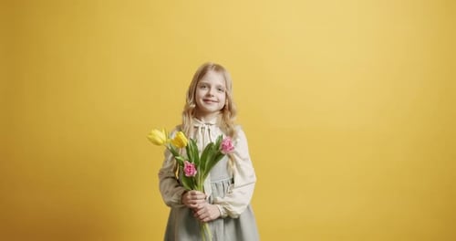 Girl Holding Tulips Smiling on Yellow Background