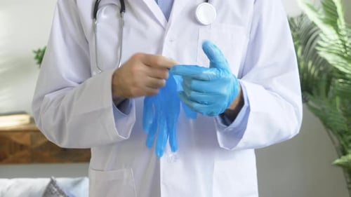 A Doctor in a White Coat Puts on Rubber Gloves against the Virus during a Pandemic, Safety