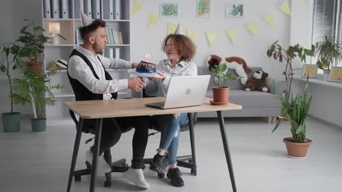 Birthday Online Joyful Couple in Party Caps Blow Out Candles on Cake During Virtual Party with