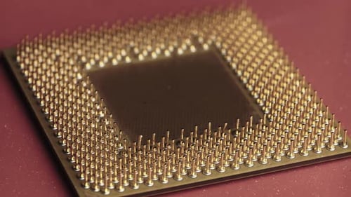 A antiga CPU de processador de computador com contatos banhados a ouro gira em fundo vermelho