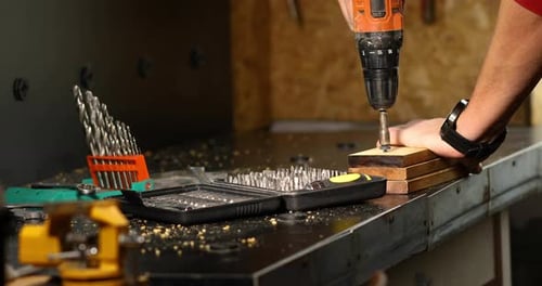Close up of man hand drilling into wood self-tapping screw twisted into place