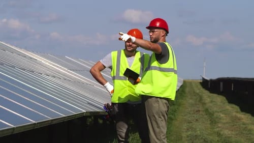 Engineers Inspect Solar Panel Installation in Field