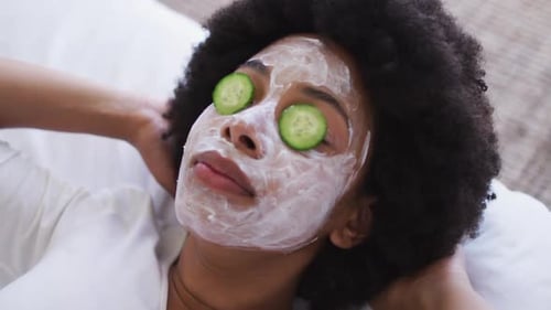 Close up of african american woman wearing face mask laying on the bed