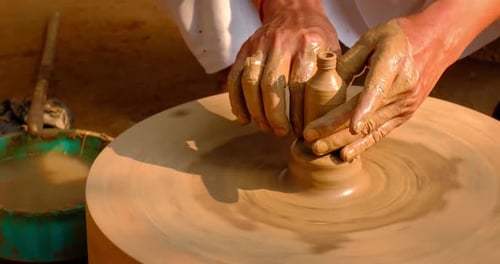 Des mains habiles de potier façonnent l'argile sur Potter Wheel et sculptent un pot en argile. Shipagramme
