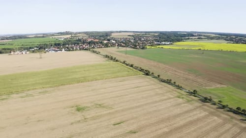 Aerial Drone Shot a Rural Area with Fields and a Road a Town in the Background