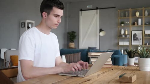 Man Leaving Desk After Completing Work on Laptop