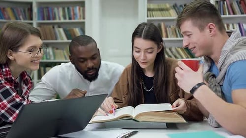 Girls and Guys which Together Reading Book while Prepare for Exams in the University Library