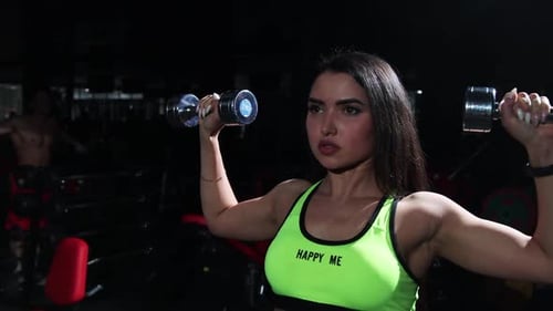 Gym Training Sportive Woman Lifting Dumbbells and Training Her Hands