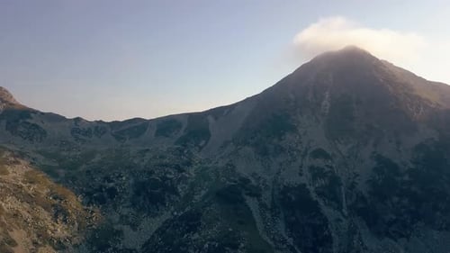 Large Drone aérien tombant lentement face à une chaîne de montagnes.