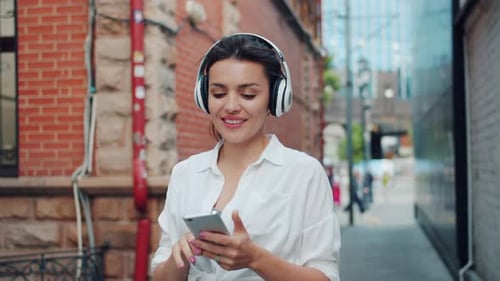 Portrait of Lady Enjoying Music in Headphone Using Smartphone Outdoors Walking