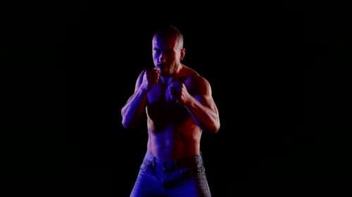 Fighter is Training Alone in Darkness Mysterious Blue Light on Naked Torso Silhouette