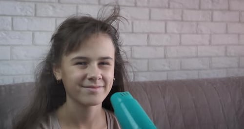 Smiling Girl Blow Drying Her Hair at Home