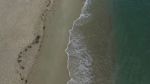 Drohnenaufnahme der tropischen Strandwellen, die die Küste erreichen