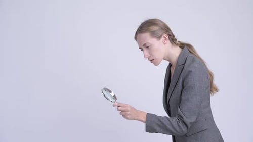 Junge blonde Geschäftsfrau mit Lupe