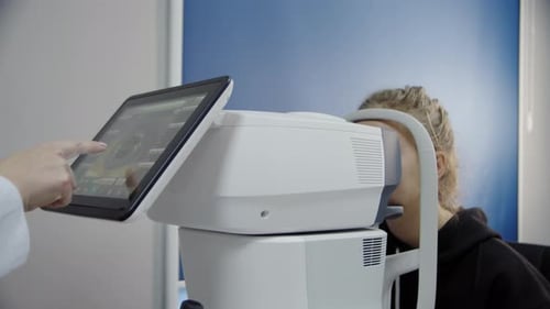 A Young Girl at an Ophthalmologist's Office Checks Her Eyesight with a Professional Device
