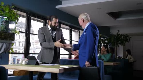 Business Colleagues Handshaking During Coffee Break