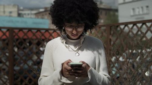 Woman Using Phone Outdoors in an Urban Setting