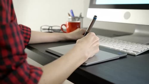 Young Adult Working on Digital Design at Desk