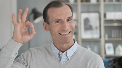 Man Makes OK Hand Gesture and Smiles