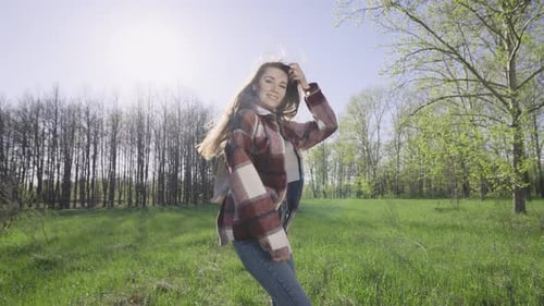 Young Woman Walking in Field on Sunny Day