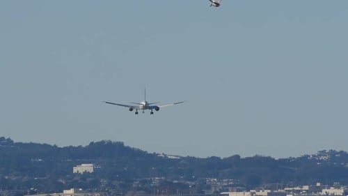 Airplane Landing Approaching Over City on a Clear Day