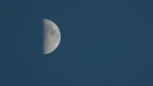 Waxing Moon Drifts Silently Across Dark Blue Sky