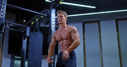 Muscular Man Flexing in a Gym