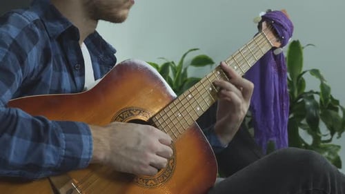 Man Plays Acoustic Guitar at Home